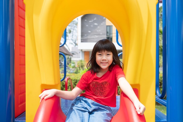 Bambini che giocano al parco giochi ragazza felice