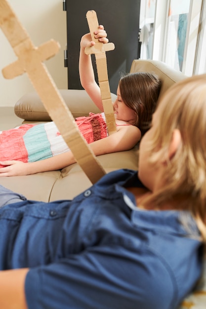 Bambini che giocano con le spade di cartone