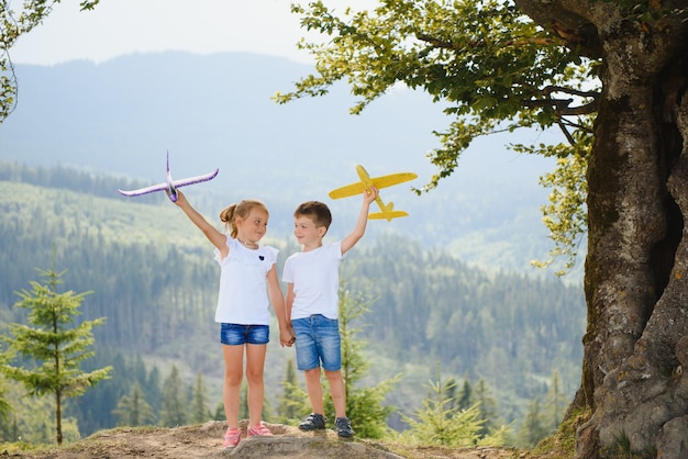 Bambini che giocano con un aeroplano giocattolo