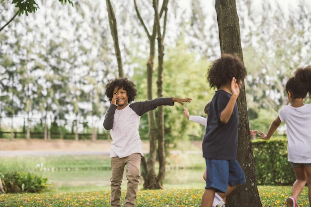 Bambini che giocano in mezzo agli alberi nel parco