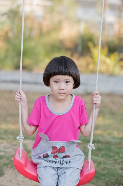 Bambini che giocano nel parco giochi, ragazza felice