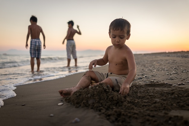 Bambini che giocano nella sabbia della spiaggia