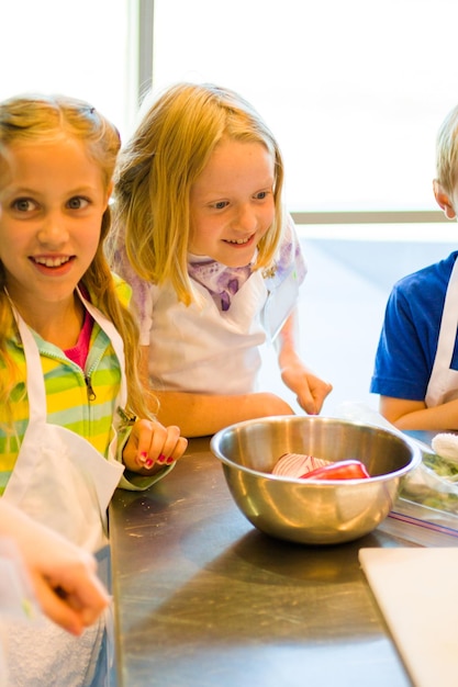 Bambini che imparano a cucinare in un corso di cucina.