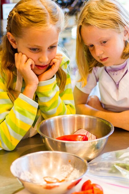 Bambini che imparano a cucinare in un corso di cucina.