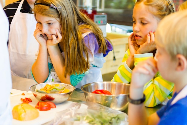 Bambini che imparano a cucinare in un corso di cucina.