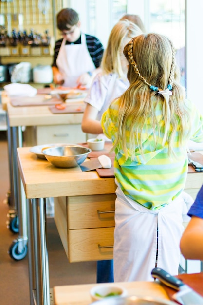 Bambini che imparano a cucinare in un corso di cucina.