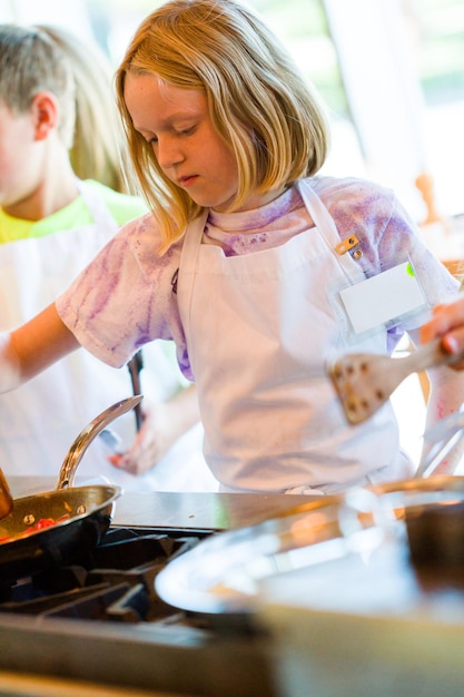 Bambini che imparano a cucinare in un corso di cucina.