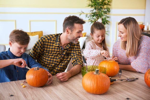 Bambini che intagliano zucche con i genitori