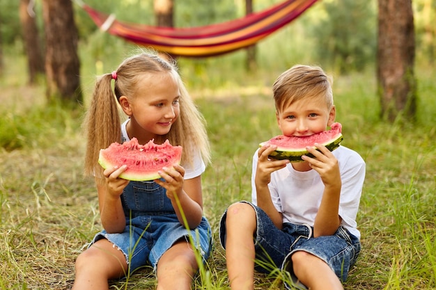 Bambini che mangiano anguria nel parco