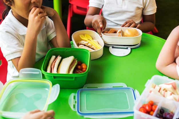 Bambini che mangiano il pranzo alle elementari