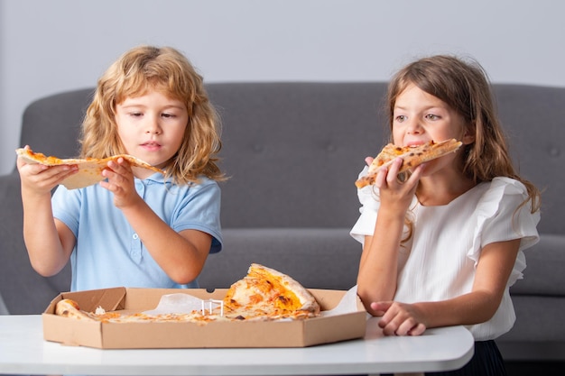 Bambini che mangiano pizza. Piccoli amici, ragazzo e ragazza mordono la pizza.