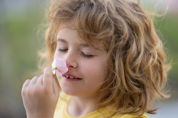 Bambini che odorano estate fiore primo piano viso bambino divertente viso vicino bambini testa ritratto vicino volti