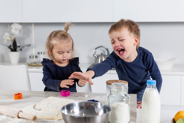 Bambini che piangono e sporcano in cucina