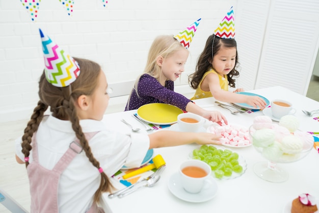 Bambini che prendono le caramelle dal tavolo alla festa di compleanno