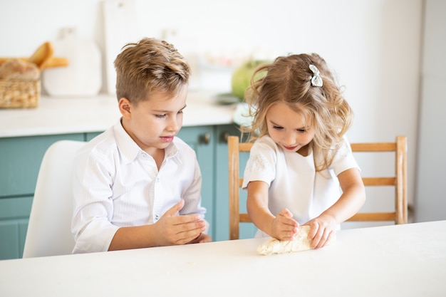 Bambini che preparano la pasta per torte a casa