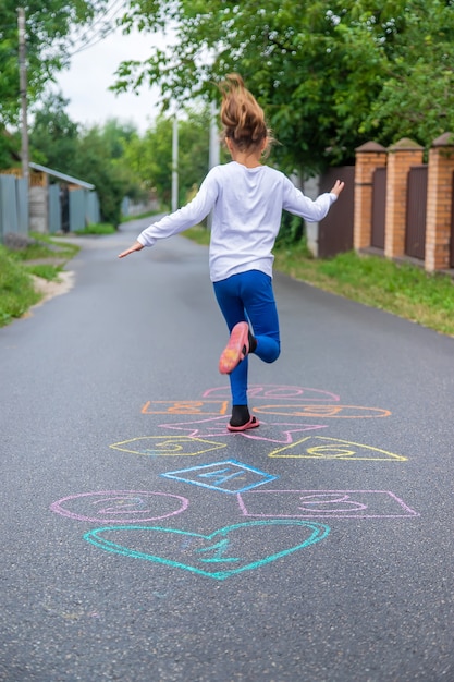 Bambini che saltano classici per strada. Messa a fuoco selettiva.