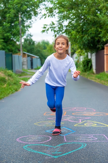 Bambini che saltano classici per strada. Messa a fuoco selettiva.