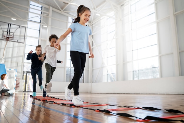 Bambini che si allenano insieme in palestra a tutto campo