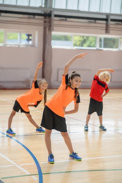 bambini che si esercitano in palestra e si piegano
