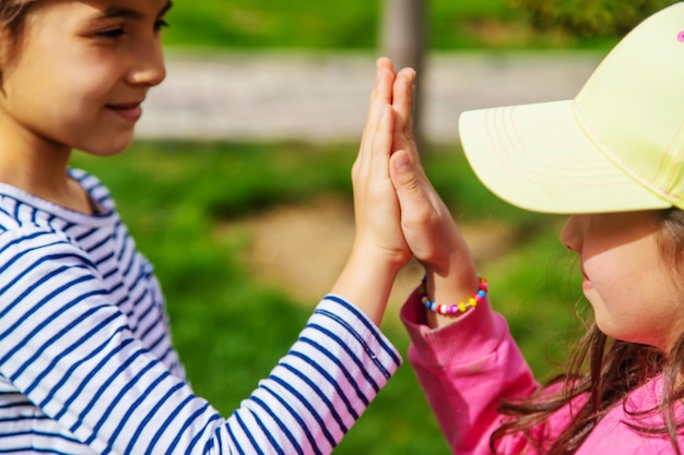 Bambini che si tengono per mano nel parco a fuoco selettivo