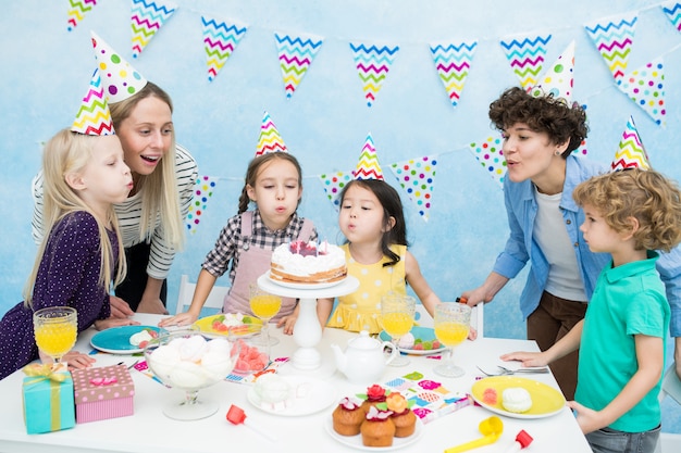 Bambini che spengono le candeline alla festa di compleanno