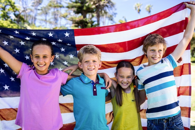 Bambini che tengono la bandiera americana nel parco