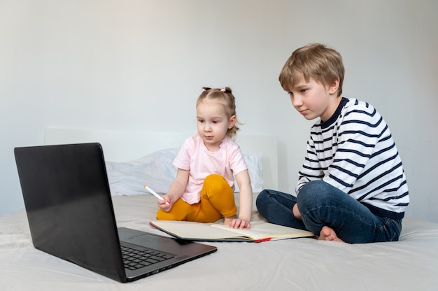 Bambini che usano laptop e cuffie mentre studiano