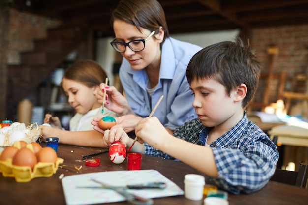 Bambini che verniciano le uova di Pasqua