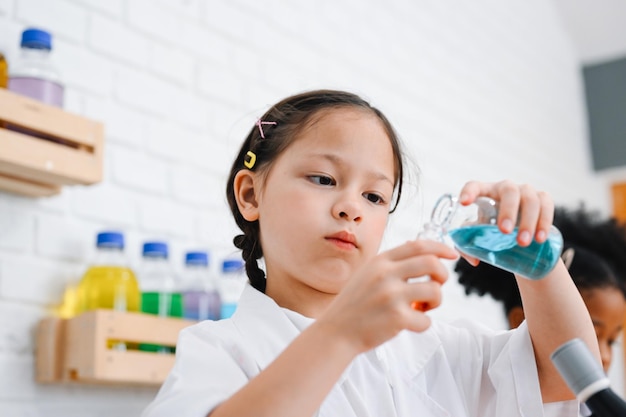 Bambini con camice da laboratorio scientifico che studiano e apprendono in materie scientifiche a scuola Bambini che imparano