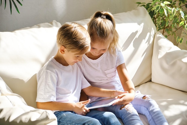 Bambini con computer tablet pc sul divano in soggiorno