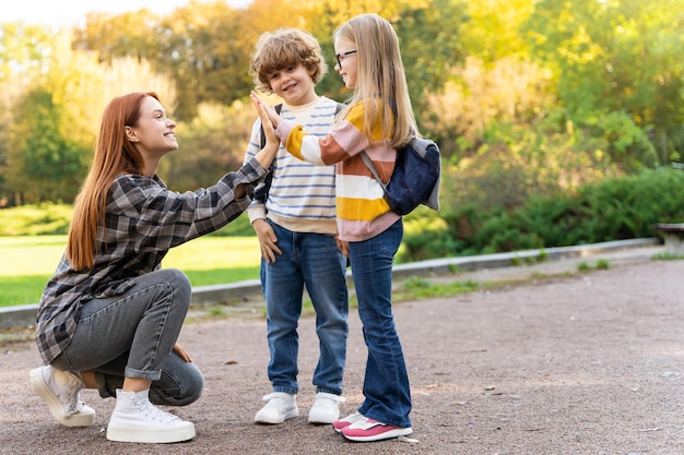 Bambini con il loro insegnante in una riunione sociale al parco impegnati nel lavoro di squadra