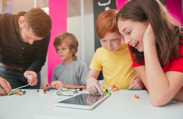 Bambini con insegnante che studiano robotica in classe