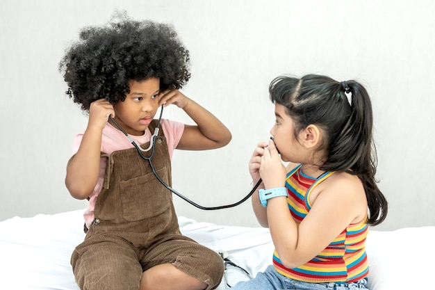 Bambini con lo stetoscopio e in attesa del medico in ospedale. Salute e benessere dei bambini.