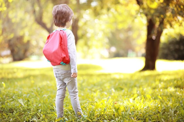 Bambini con valigette per una passeggiata nel parco. Vacanza scolastica. L'inizio degli studi dei bambini.