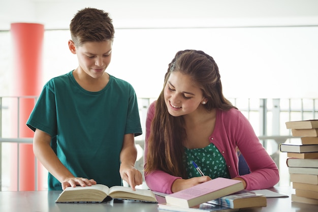 Bambini della scuola a fare i compiti in biblioteca a scuola