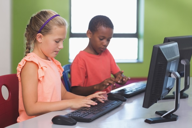 Bambini della scuola che utilizzano computer nell'aula