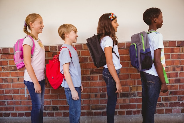 Bambini della scuola in piedi nel corridoio della scuola