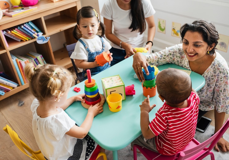 Foto bambini della scuola materna che giocano con l&#39;insegnante nell&#39;aula