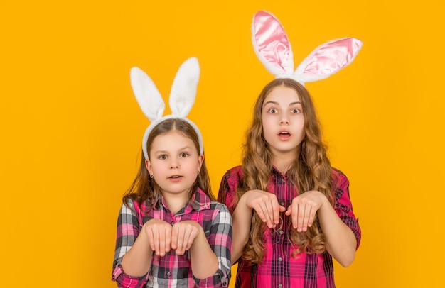 Bambini di Pasqua scioccati in orecchie da coniglio su sfondo giallo