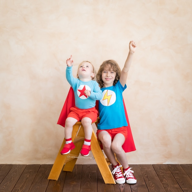 Bambini di supereroi che giocano in casa