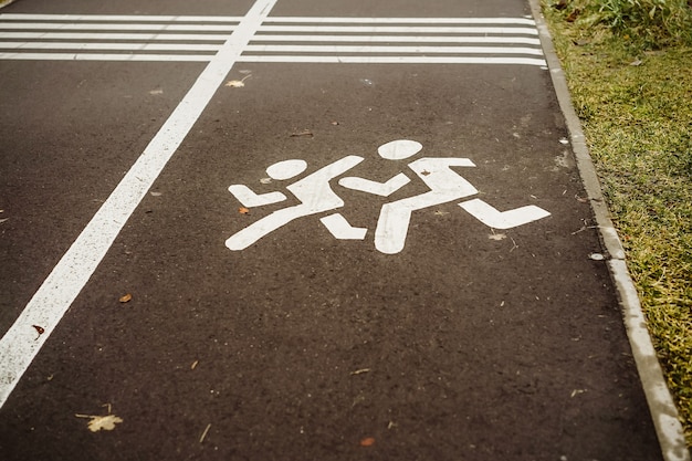 Bambini disegnati in bianco segno sulla pista ciclabile nel parco autunnale di San Pietroburgo