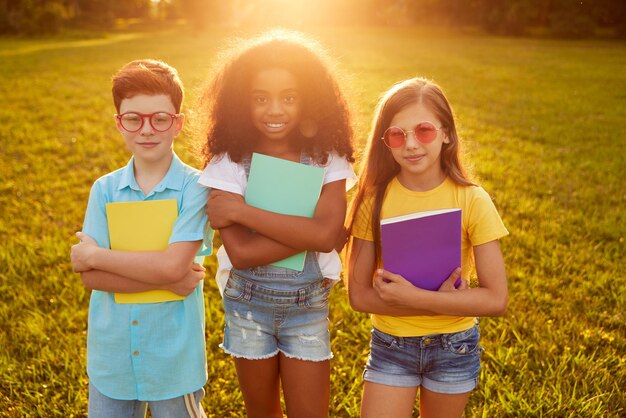 Bambini diversi con libri di testo nel parco