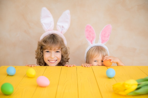 Bambini divertenti che indossano il coniglietto di Pasqua. I bambini si divertono a casa