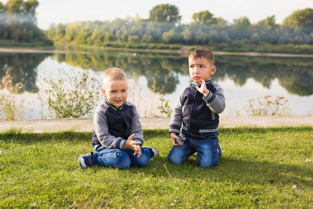 Bambini e concetto della natura - due fratelli che si siedono sull'erba sopra lo spazio della natura