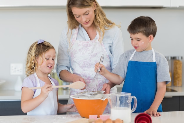 Bambini e madre che cuociono i biscotti