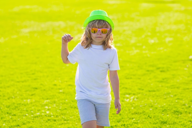Bambini estivi in cappello e occhiali da sole divertenti emozioni per bambini all'aperto primo piano ritratto di un piccolo chi carino