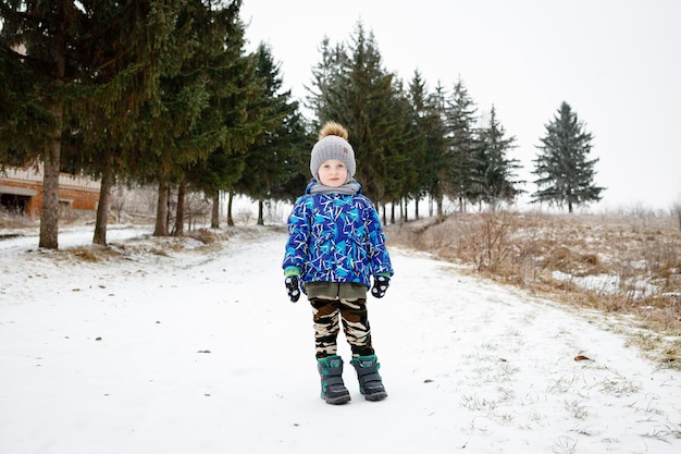 Bambini felici che corrono nella bellissima foresta o parco invernale