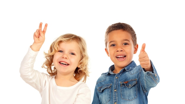 Bambini felici che dicono Ok e che esaminano macchina fotografica isolata su un bianco