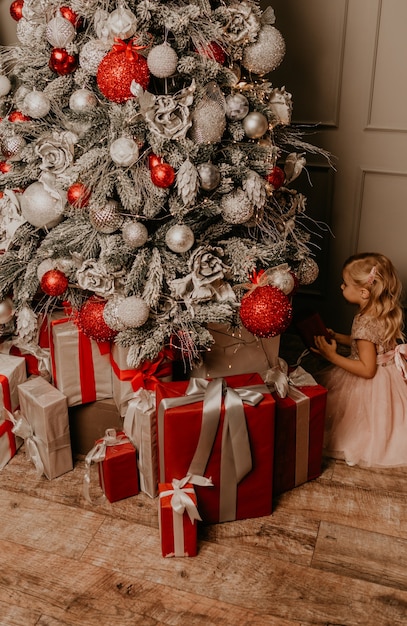 Bambini felici che festeggiano il nuovo anno e il Natale all'albero di Natale decorato e alle ghirlande