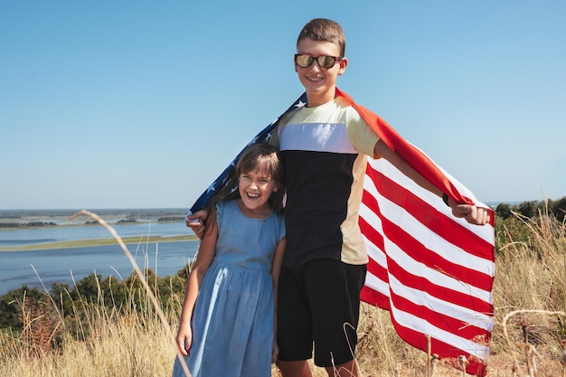 Bambini felici che giocano con la bandiera americana all'aperto